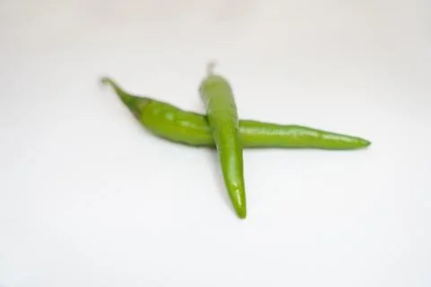 Two green chilly in white background Stock Photos