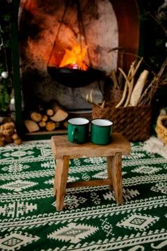 Two green cups stand on a stool against the background of the hearth in the c Foto stock