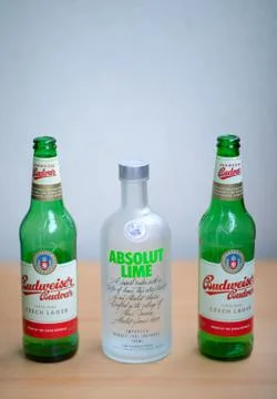 Two green empty Budweiser beer bottles and vodka Absolut Lime Stock Photos