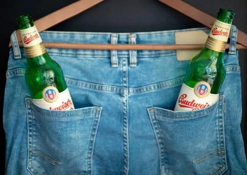 Two green empty Budweiser beer bottles in a pants pocket. Stock Photos