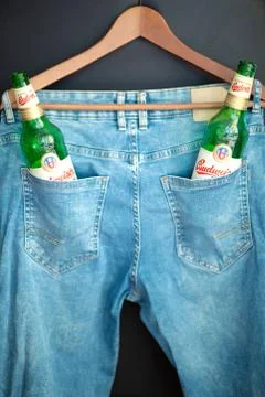 Two green empty Budweiser beer bottles in a pants pocket. Stock Photos