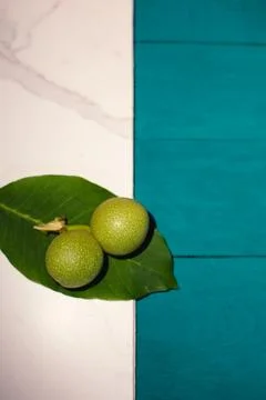 Two green nuts and a leaf on a blue-white background Stock Photos