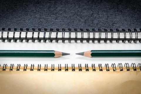 Two green pencils between note books Stock Photos