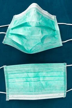 Two green protective face mask on a blue background. Photos
