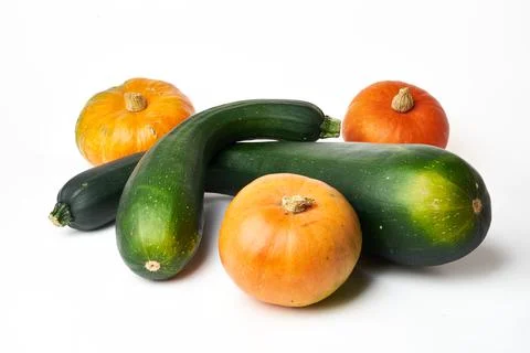 Two green squash and three orange pumpkins on a white background Stock Photos