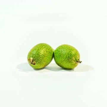Two green walnuts on white background Stock Photos