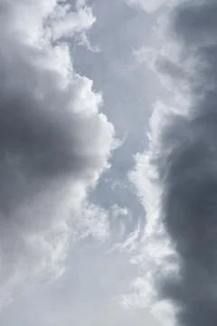 Two grey clouds passing each other with gap in middle Stock Photos