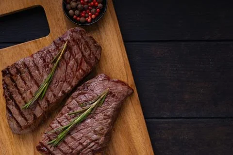 Two grilled beef steak on cutting board with copy space Stock Photos