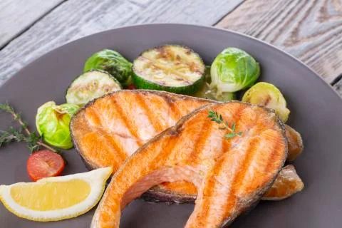 Two grilled salmon steaks with mix of vegetables Stock Photos