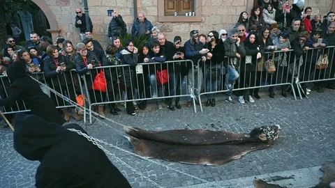 Two grim reapers drag cowhide in chains, carnival in sardinia Stock Footage 106213611