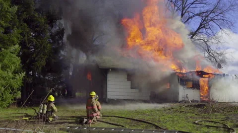 Two groups of firemen spray burning house Stock Footage 60985916