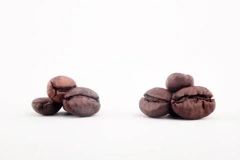 Two Groups of Roasted Coffee Beans Close Up on White Background Stock Photos