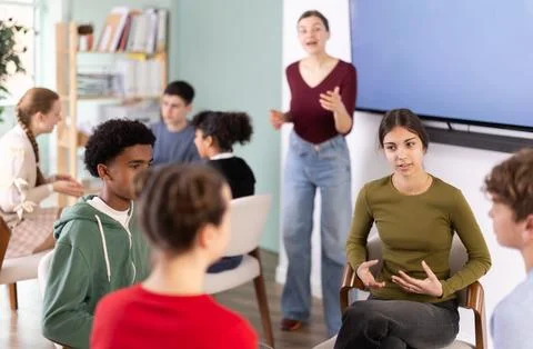 Two groups of students sit in a circle and discuss a topic Stock Photos