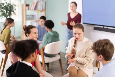 Two groups of students sit in a circle and discuss a topic Stock Photos