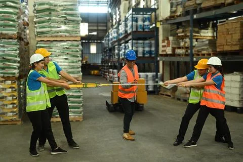 Two groups of warehouse worker pulling opposite ends of rope. Concept of Foto stock