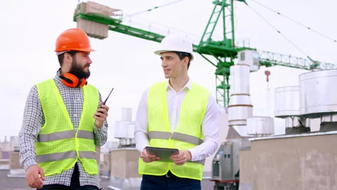 Two guy with safety helmets one businessman and one of the guy are main Stock Footage 150384546