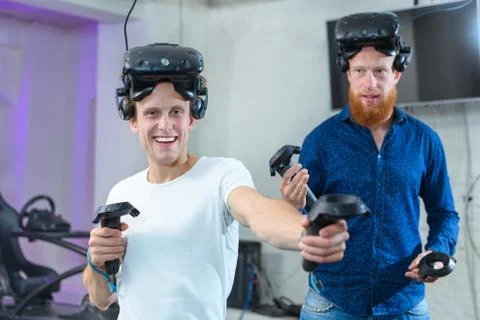 Two guys are preparing for virtual reality games, they are wearing virtual re Stock Photos