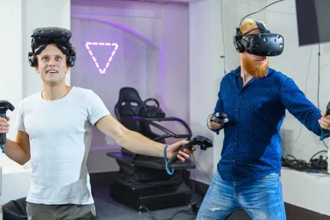 Two guys are preparing for virtual reality games, they are wearing virtual re Stock Photos