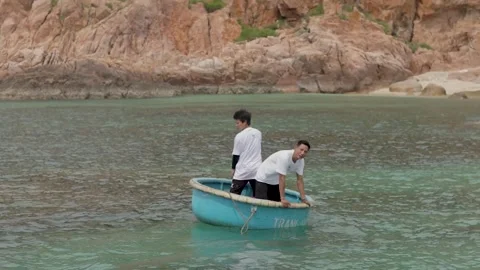 Two guys are sailing on a round Vietnamese boat Stock Footage 291775281