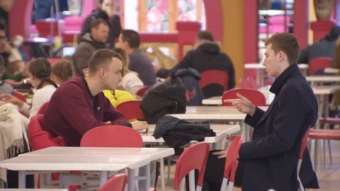 Two guys are sitting in a fast food restaurant. communicate, mobile phones. Kiev Stock Footage 113802110