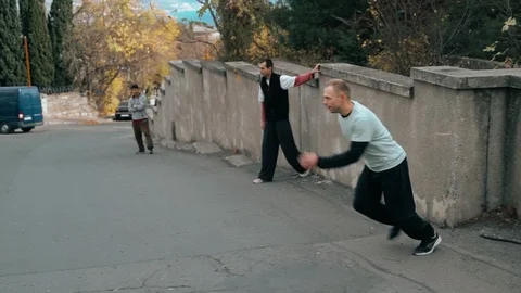 Two guys are training parkour. Jump on the walls and railings in the city on an Stock Footage 120241241