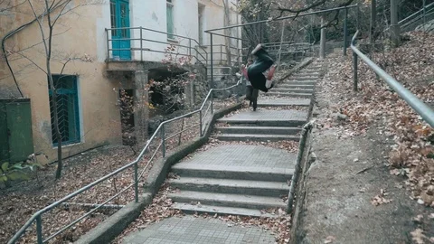 Two guys are training parkour. They jump down the stairs doing a backflip on an Video stock 120241608