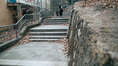 Two guys are training parkour. They jump down the stairs doing a backflip on an Video stock 120241668