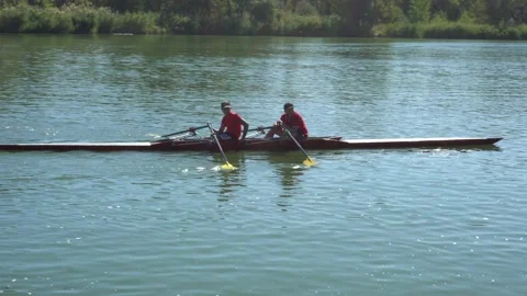 Two guys athletes train rowing in the river Stock Footage 139279827
