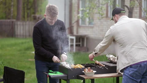 Two guys cooking meat Stock Footage 277106275