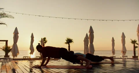 Two guys doing wellness yoga on the beach at sunrise. Sports and morning Stock Footage 249235738
