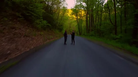 Two Guys on a Forest Road Flying a Drone Stock Footage 240518227