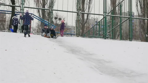 Two guys go down in a sleigh from a snowy hill. Slow motion 01.10.2020 Ukraine Stock Footage 126332762