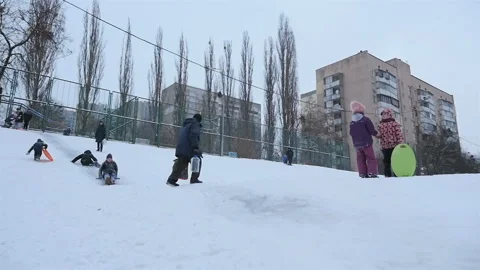 Two guys go down a snowy hill. Slow motion 01.10.2020 Ukraine, Kiev Stock Footage 126652921