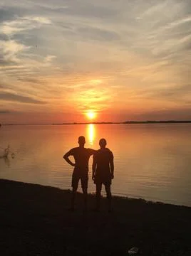 Two guys hugging at sunset, two at sunset Stock Photos