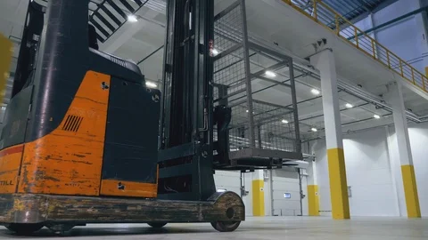 Two guys jump over a reach truck in an empty logistic center Video stock 104306992