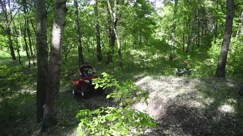 Two guys, men on ATVs drive up a steep slope. Walking on ATVs in the forest. Stock Footage 139884558