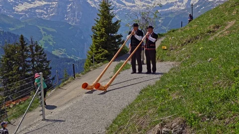 Two guys playing the alpine horn, Schynige Platte in Switzerland Stock Footage 126093153