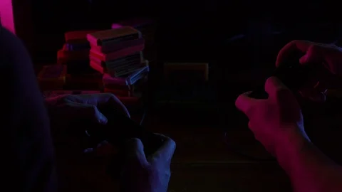 Two guys playing video games in dark room by light of television Stock Footage 126094305