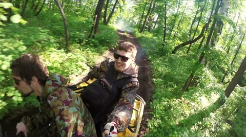 Two guys on quad ride through the forest Stock Footage 57706930