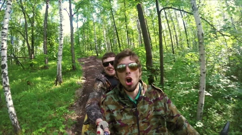 Two guys on quad ride through the forest Stock Footage 57707027