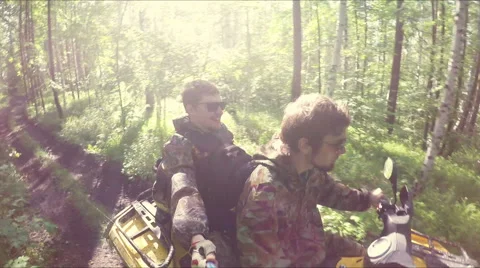 Two guys on quad ride through the forest Stock Footage 57707028