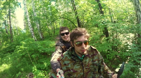 Two guys on quad ride through the forest Stock Footage 57707116