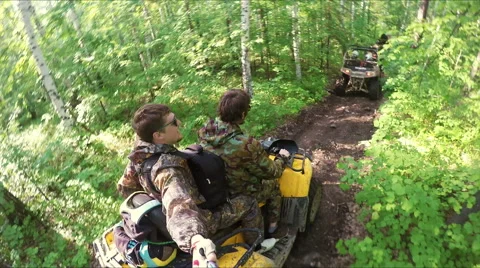 Two guys on quad ride through the forest Stock Footage 57707131