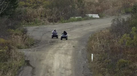 Two Guys Riding ATV's on Dirt Road in Alaska Stock Footage 12189458