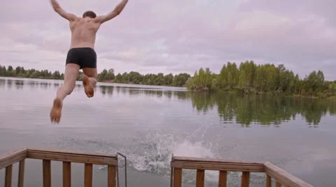 Two guys run and jump into the water Stock Footage 44449067