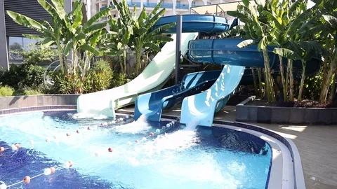 Two guys sliding down fun water slide at sunny day Stock Footage 101266467