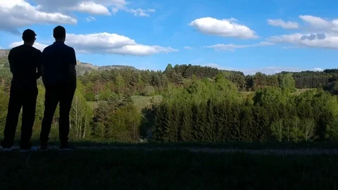 Two guys stand and look at the forest and the sky Stock Footage 108060859