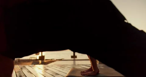 Two guys stretch to the side and do yoga on a sunny beach in the morning Stock Footage 249435840