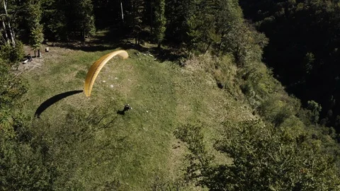 Two guys taking of from the green hill with tandem paraglide on a sunny day Vídeo Stock 120116788