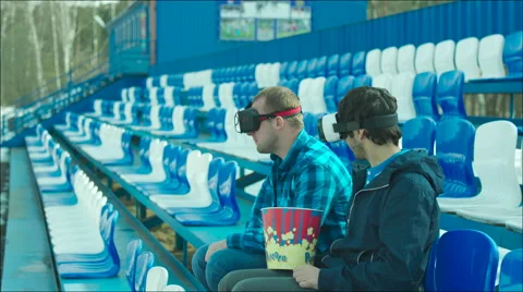 Two guys in VR glasses sitting on the tribune Stock Footage 63554574